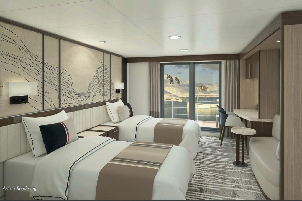 Cabin with 2 beds, desk & chair and private balcony.