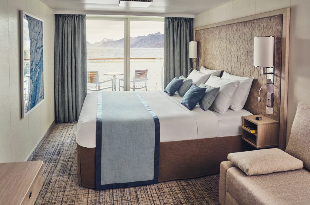 Queen bed with sliding glass door looking out on balcony.