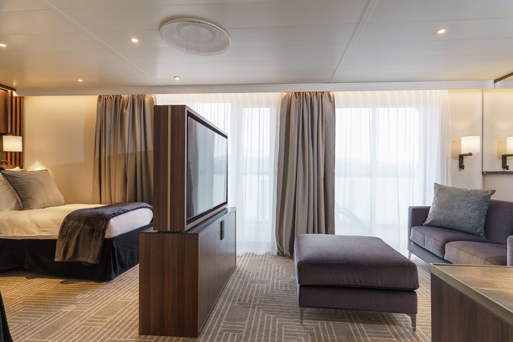 Terrace Suite showing double bed, TV, sitting area and large windows. 