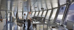 The bridge of the Magellan Explorer with 2 officers at the controls and looking out the windows