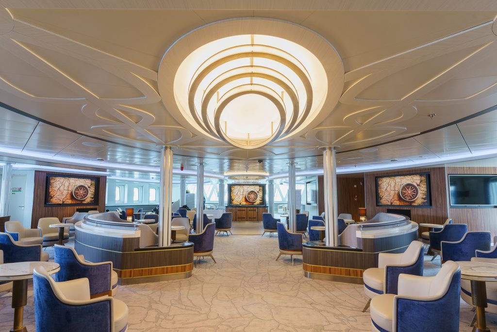 Lounge with chairs, flat screen TV's and windows on Ocean Explorer. 