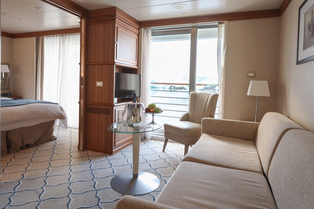 Couch, bed and sliding glass door in Exploris One cabin. 