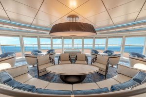 Lounge with chairs and floor to ceiling windows. 