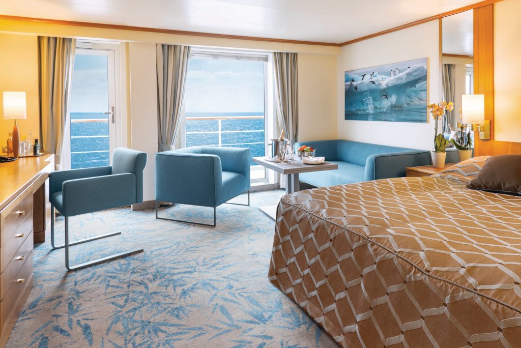 Double bed with couch and floor to ceiling window in Owners Suite on Seaventure