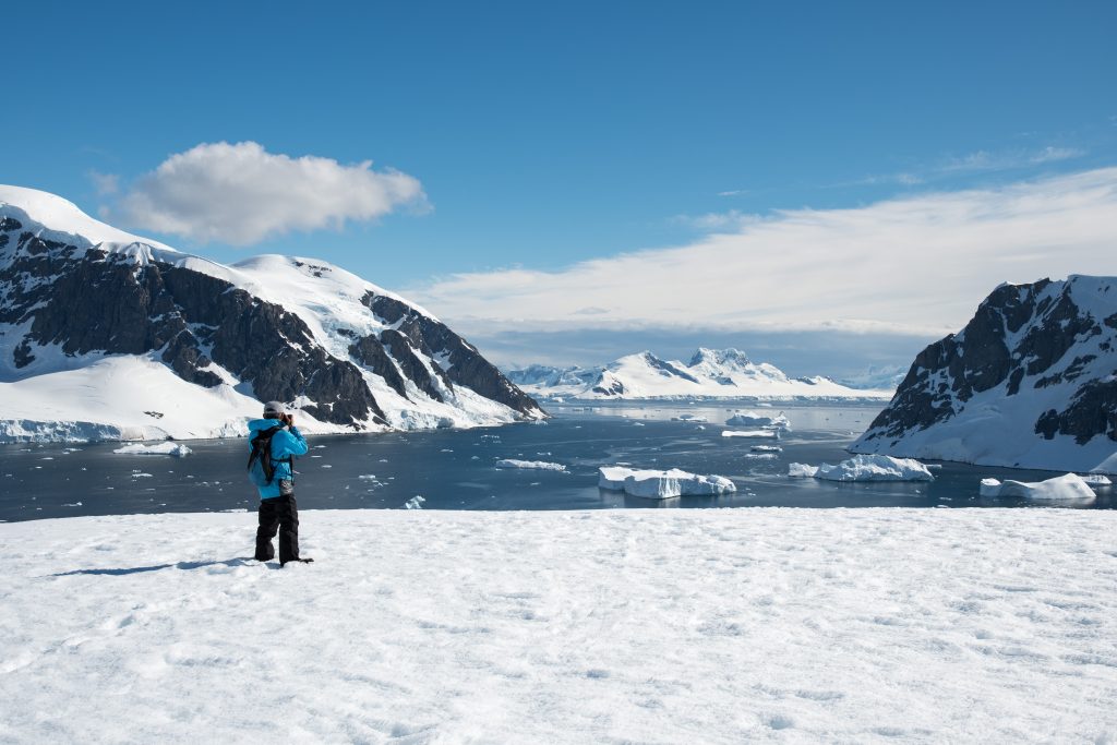 Photographer shooting a beautiful landscape in Antarctica
