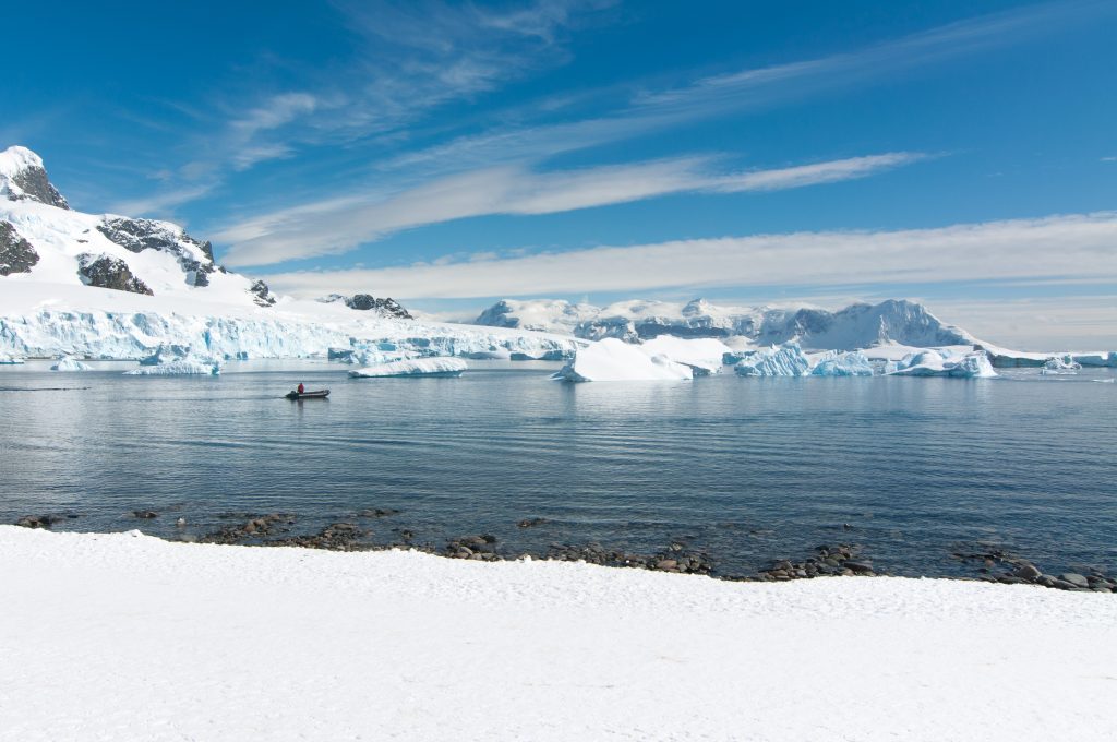 Snowy landscape with zodiac on the water.