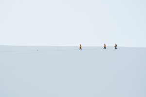 Three people hiking in a snowy landscape.