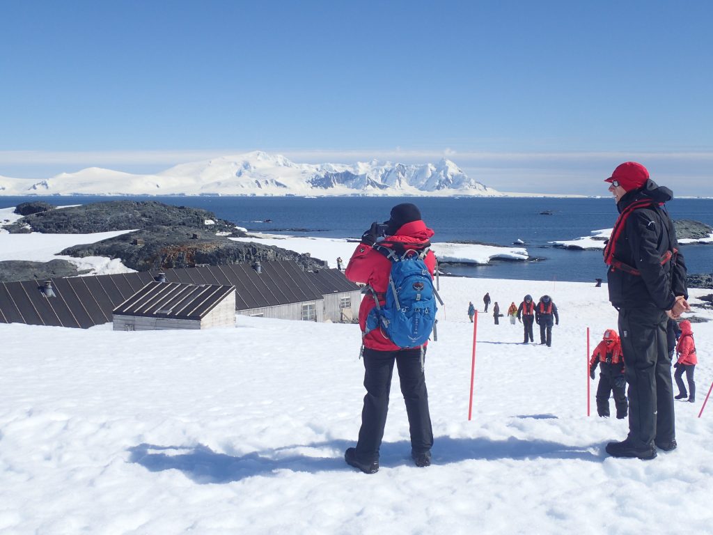 Guests standing on the snow at Base W, Detaille Island.