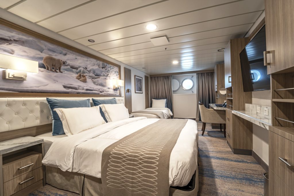 Interior of Triple cabin showing double bed, 1 single bed and porthole