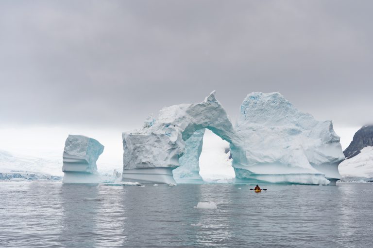 PL-Antarctica-iceberg-arch-kayaker