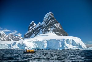 Zodiac cruising along glacier face.