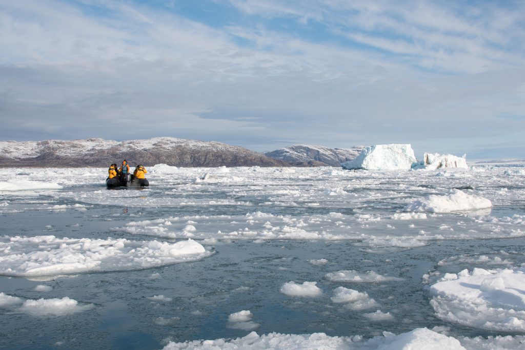 Passengers on a zodiac cruise with sea ice and icebergs