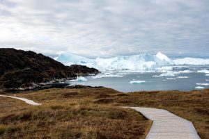 Boardwalk in Ilulissat with icebergs in background.