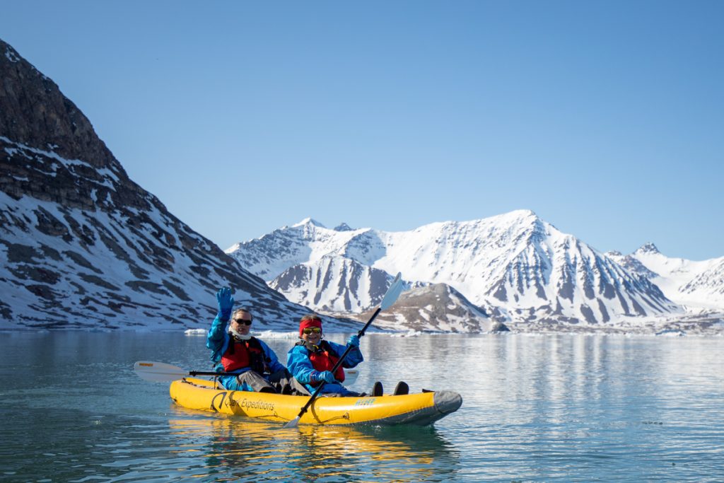 Kayakers in a snowy fjord. 