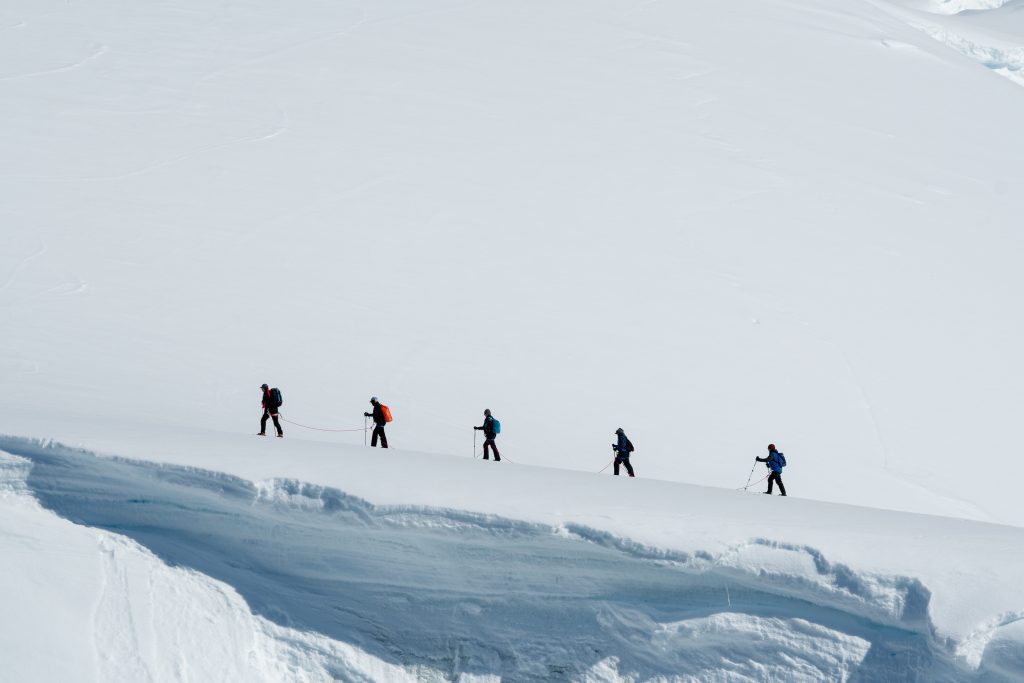 A line of hikers on the snow in Antarctica.