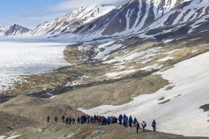 Guest hiking up hillside in Svalbard. 