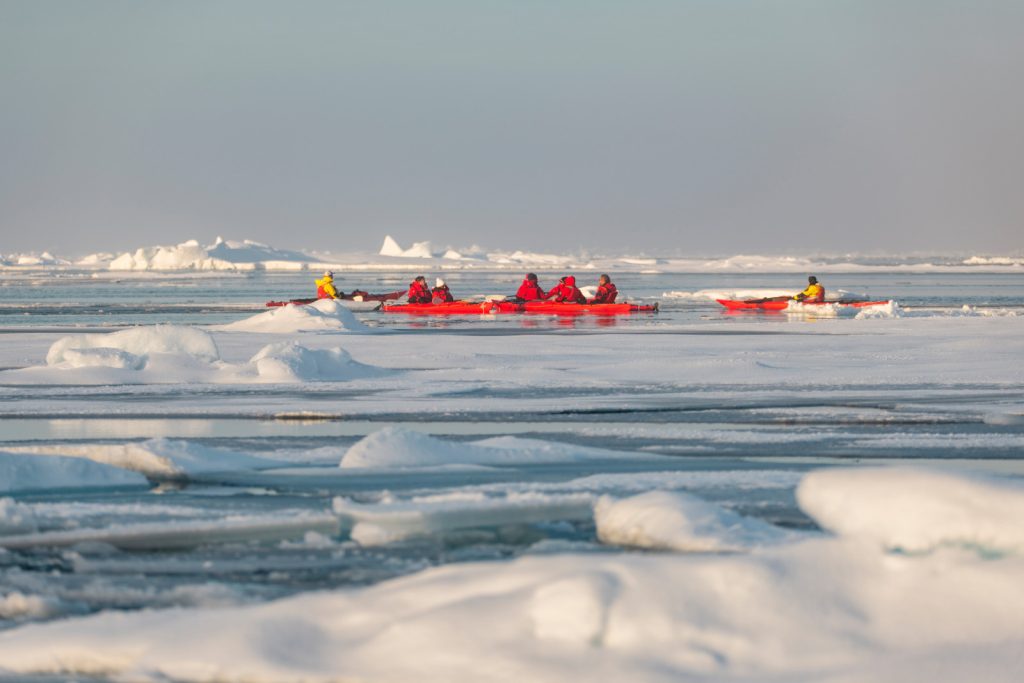 Kayakers in icy Arctic waters.