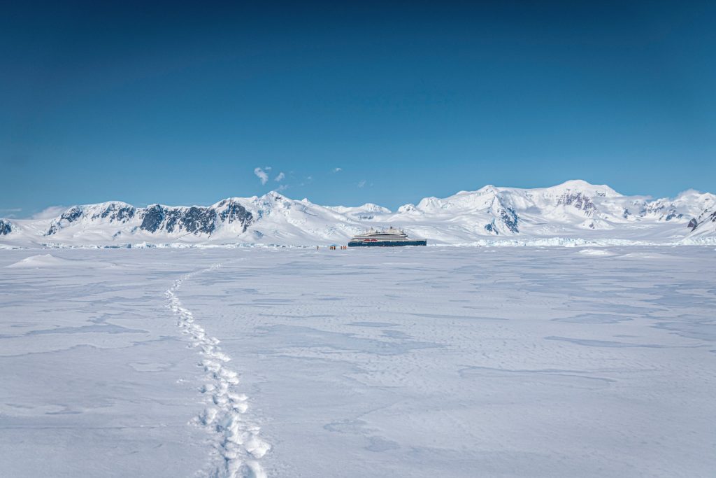 Tracks in the snow on sea ice leading to the Le Commandant Chrcot ship.