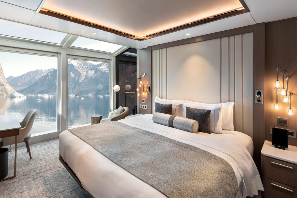Bedroom with huge floor to ceiling windows and king bed. 