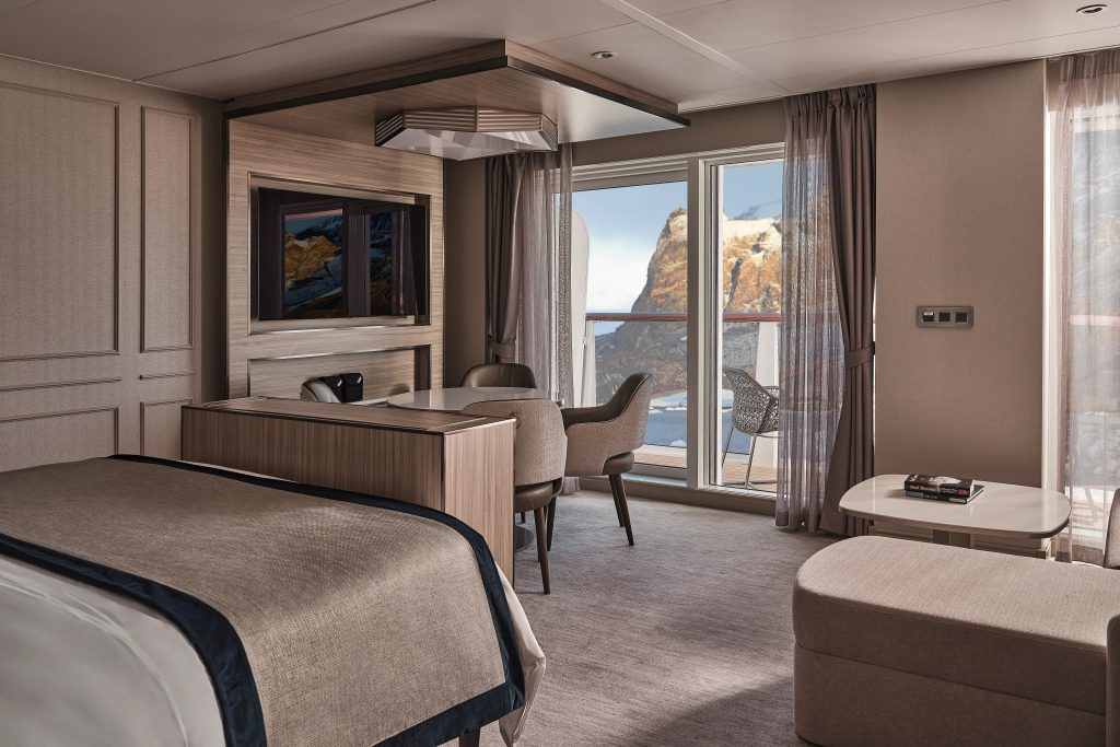 Silver Suite on the Silver Endeavour with bed, sitting area and sliding glass door with sea views. 