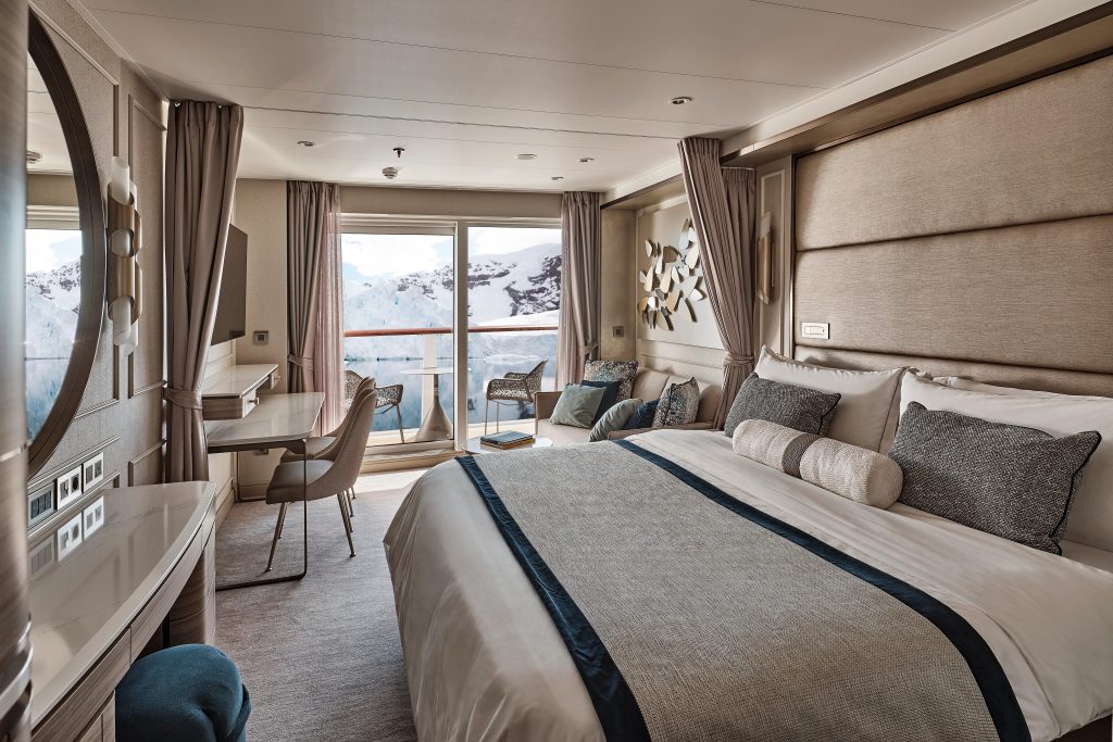 King bed, couch and floor to ceiling sliding glass door in Premium Veranda Suite on Silver Endeavour. 