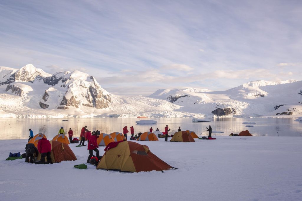 Tents on the snow with mountain landscape. 