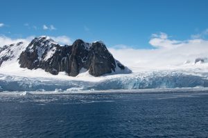 An Antarctic landscape with glacier & rugged mountains.