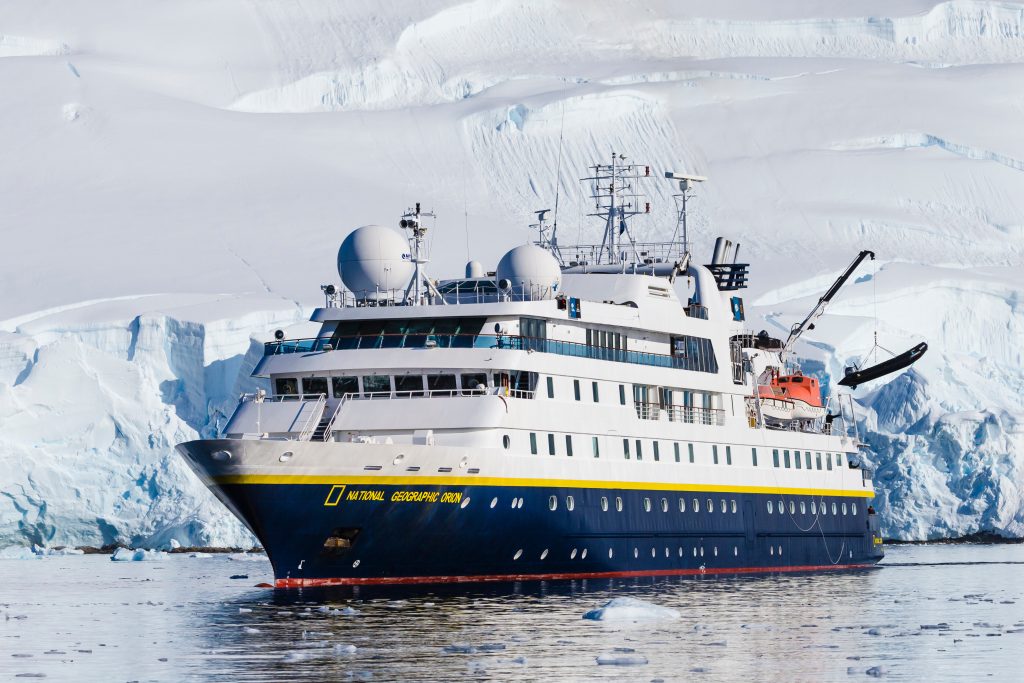 The ship National Geographic Orion on the water with glacier in background. 