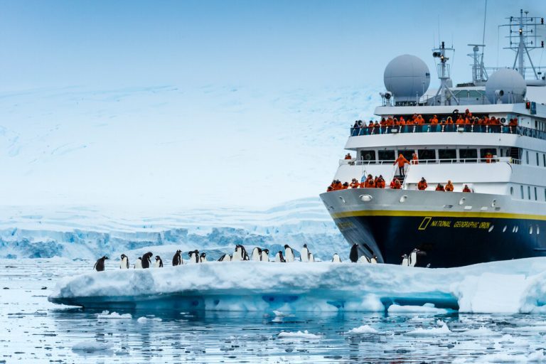 National Geographic ship with iceberg and penguins in foreground