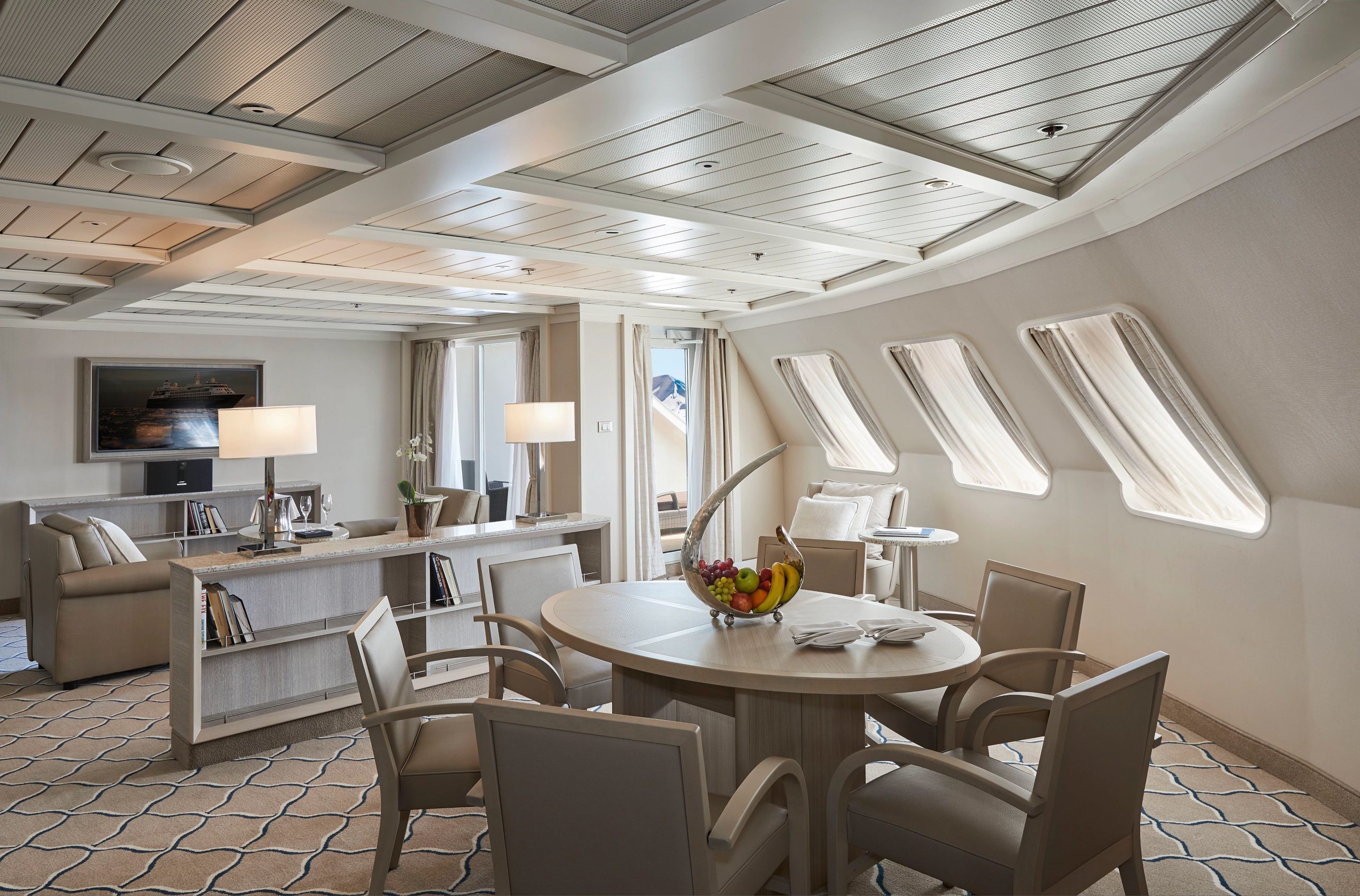 Grand Suite on Silver Cloud with circular dining table, couch, flat screen TV and private balcony