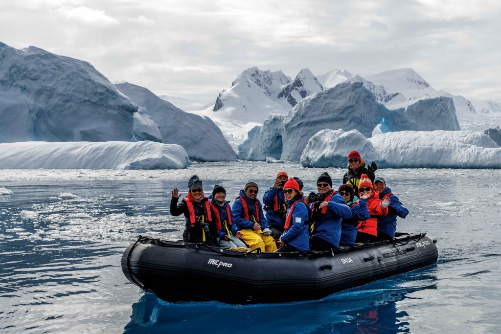 A zodiac full of guests on the water in Antarctica. 