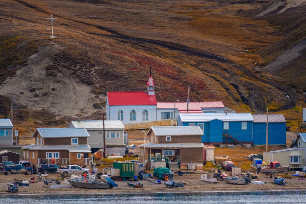 An Arctic village in front of steep slope.