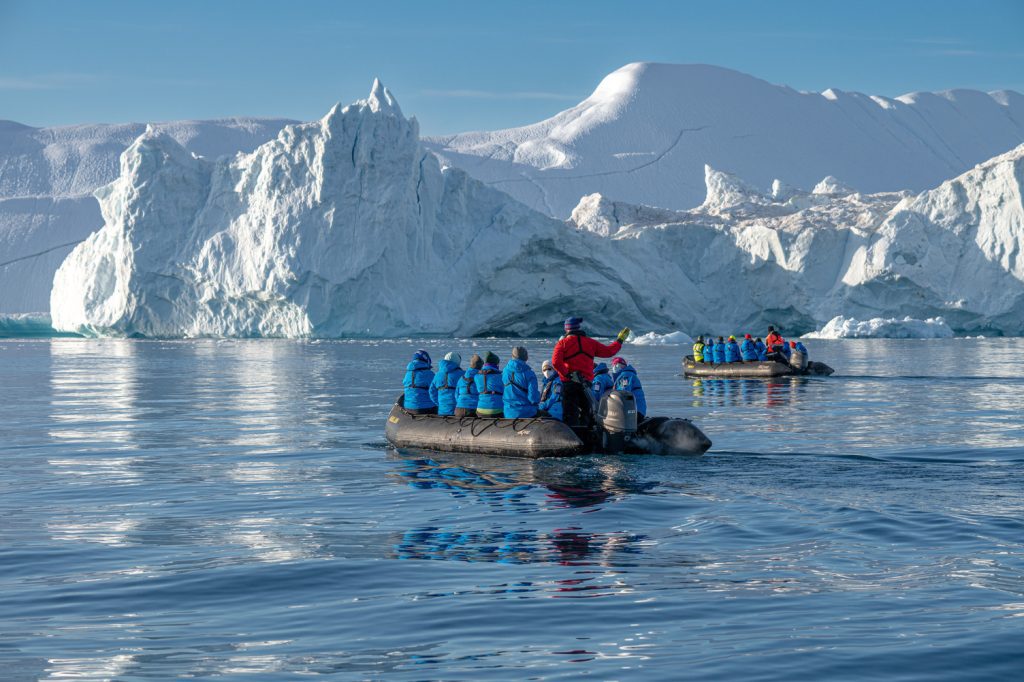 Zodiac cruising near icebergs in Greenland.