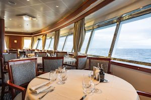Discoverer restaurant with circular table and large windows with ocean views.