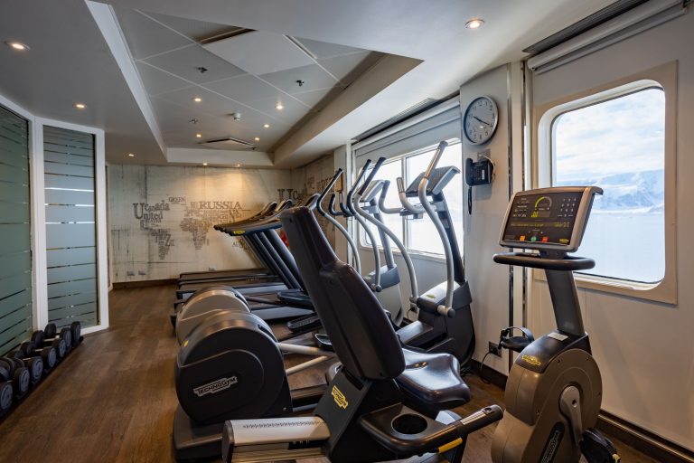 Exploris One Fitness Center with treadmills, ellipticals and free weights. Three large windows with ocean views.