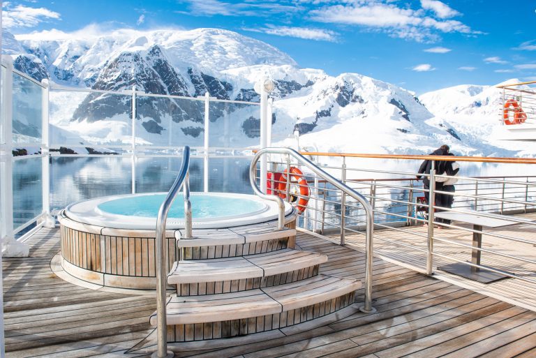 Outdoor Jacuzzi on Exploris One with view of stunning snow covered mountains in background.