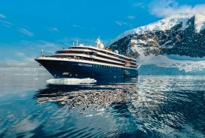 Exterior view of the ship World Voyager in Antarctica with glacier in background
