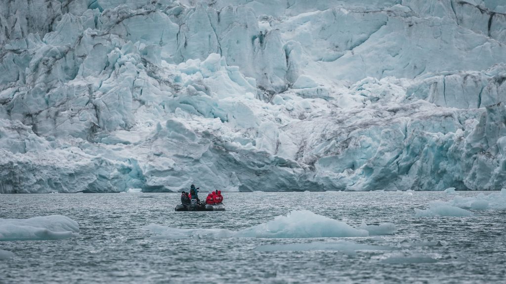 Zodiac in front of huge glacier face.