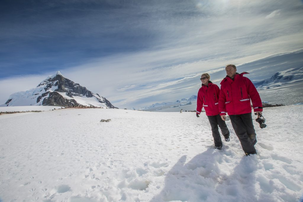 Two guests hiking in the snow in Antarctica. 