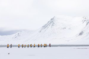A line of guests hiking on the snow.