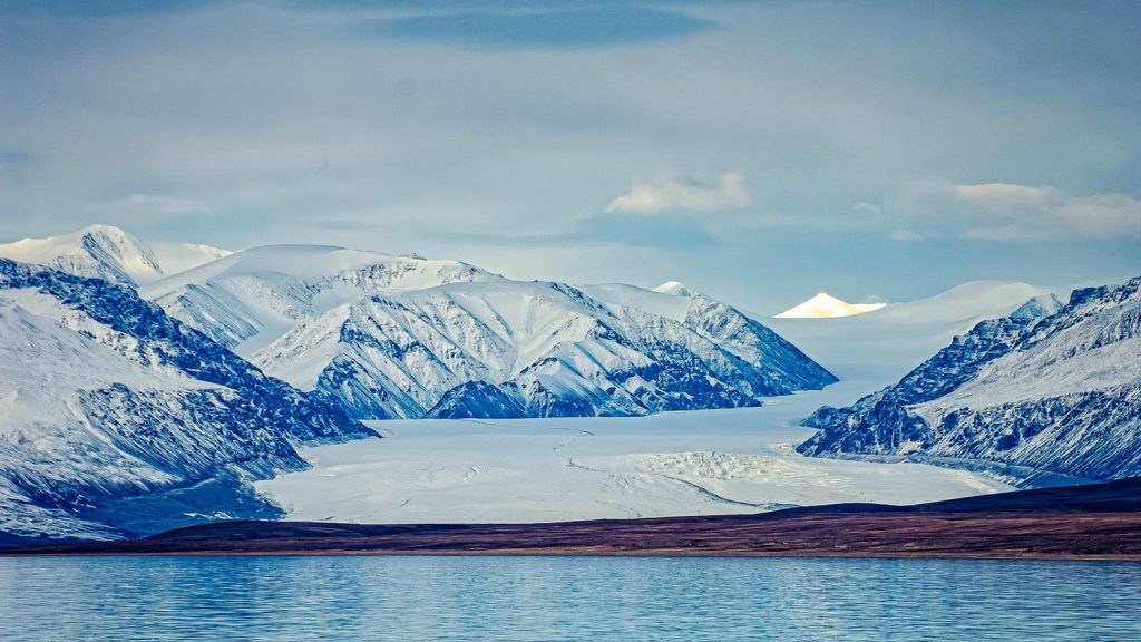 A large glacier flowing from mountains. 