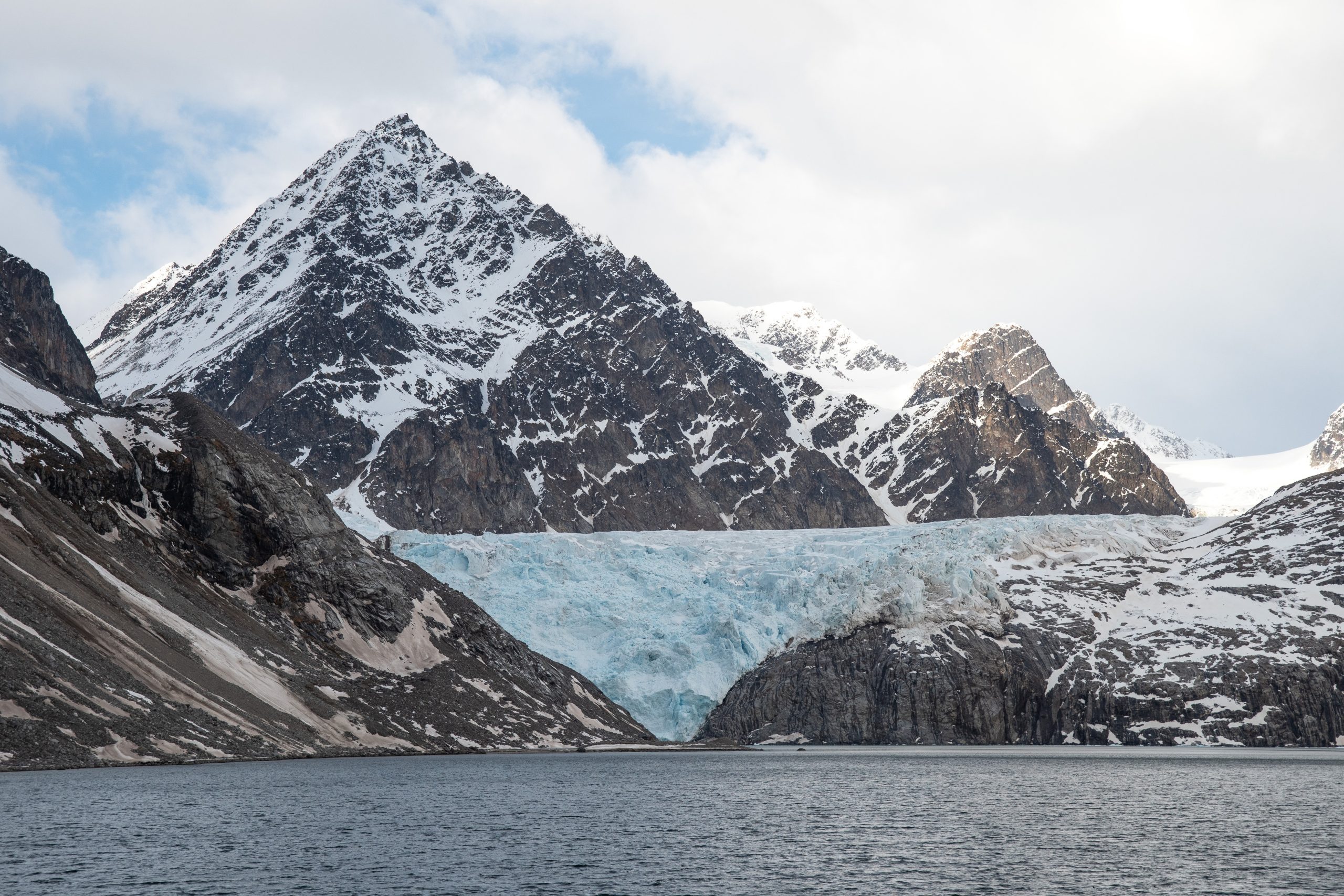 Hanging glacier with pointed mountain peaks in Svalbard.