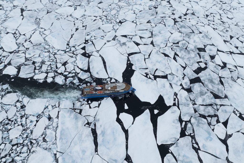 Bird's eye view of ship sailing through Arctic pack ice. 