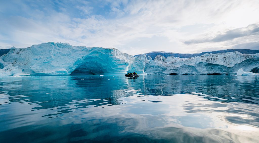 A zodiac cruising in front of a glacier. 