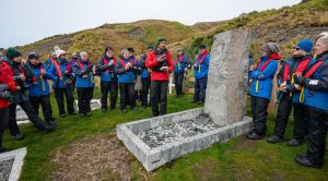 Guests standing around Shackleton's grave on South Georgia Island. 