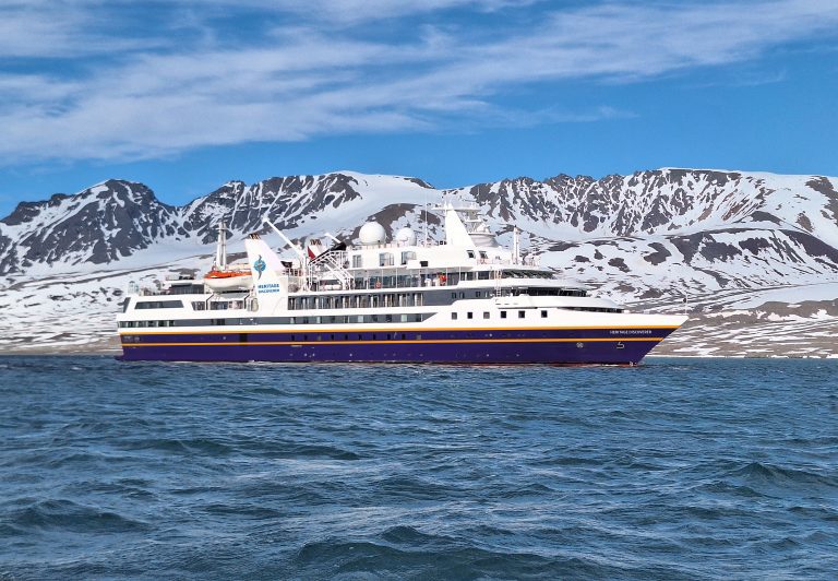 The ship Heritage Discoverer sailing along coastline.