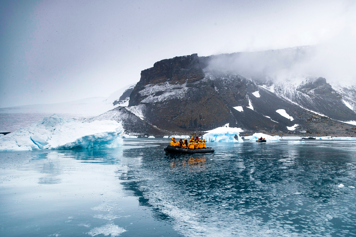 Zodiac on the water next to icebergs.