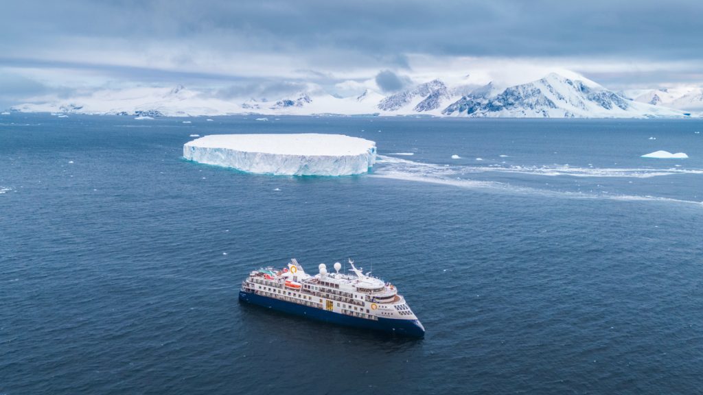 Bird's eye view of the ship Ocean Explorer sailing in Antarctica.