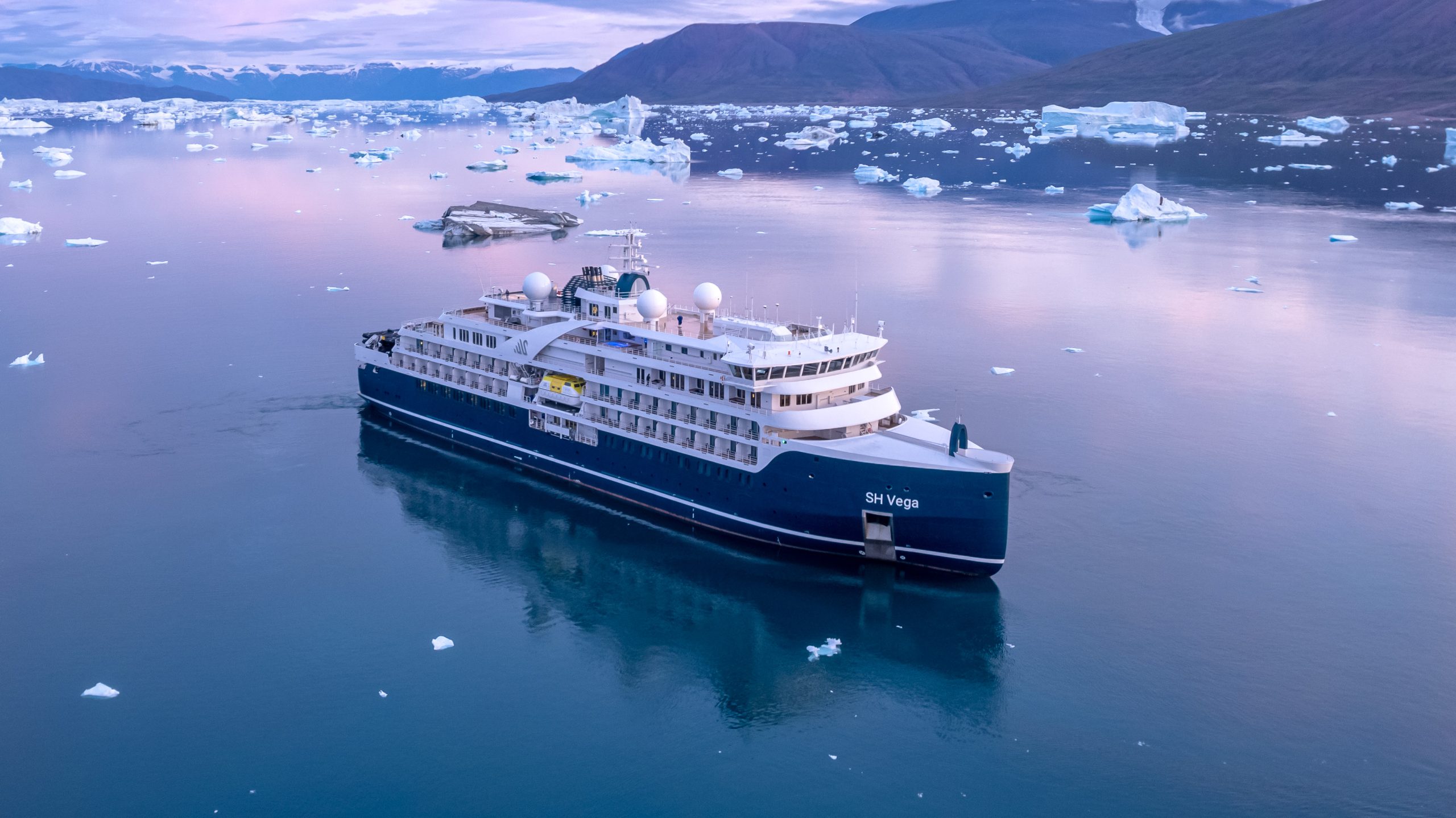 The ship SH Vega sailing in the Arctic and sunset.