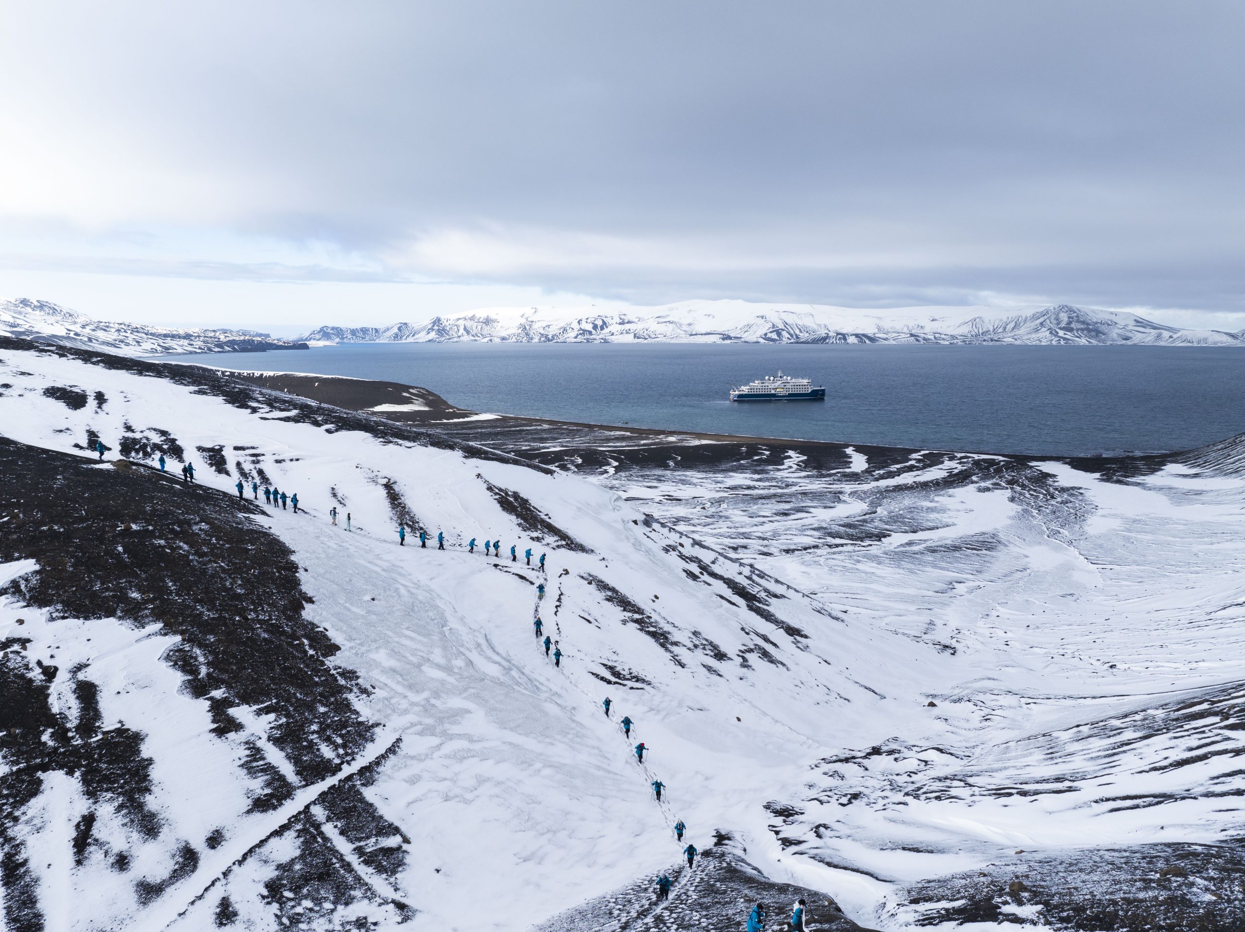 Antarctic landscape with the SH Vega on water in the distance.